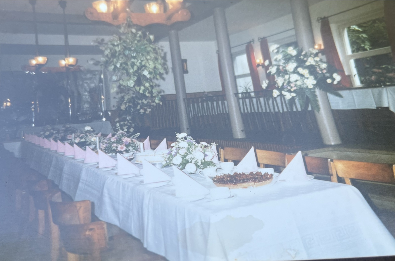 Festlich gedeckte lange Tafel im Saal