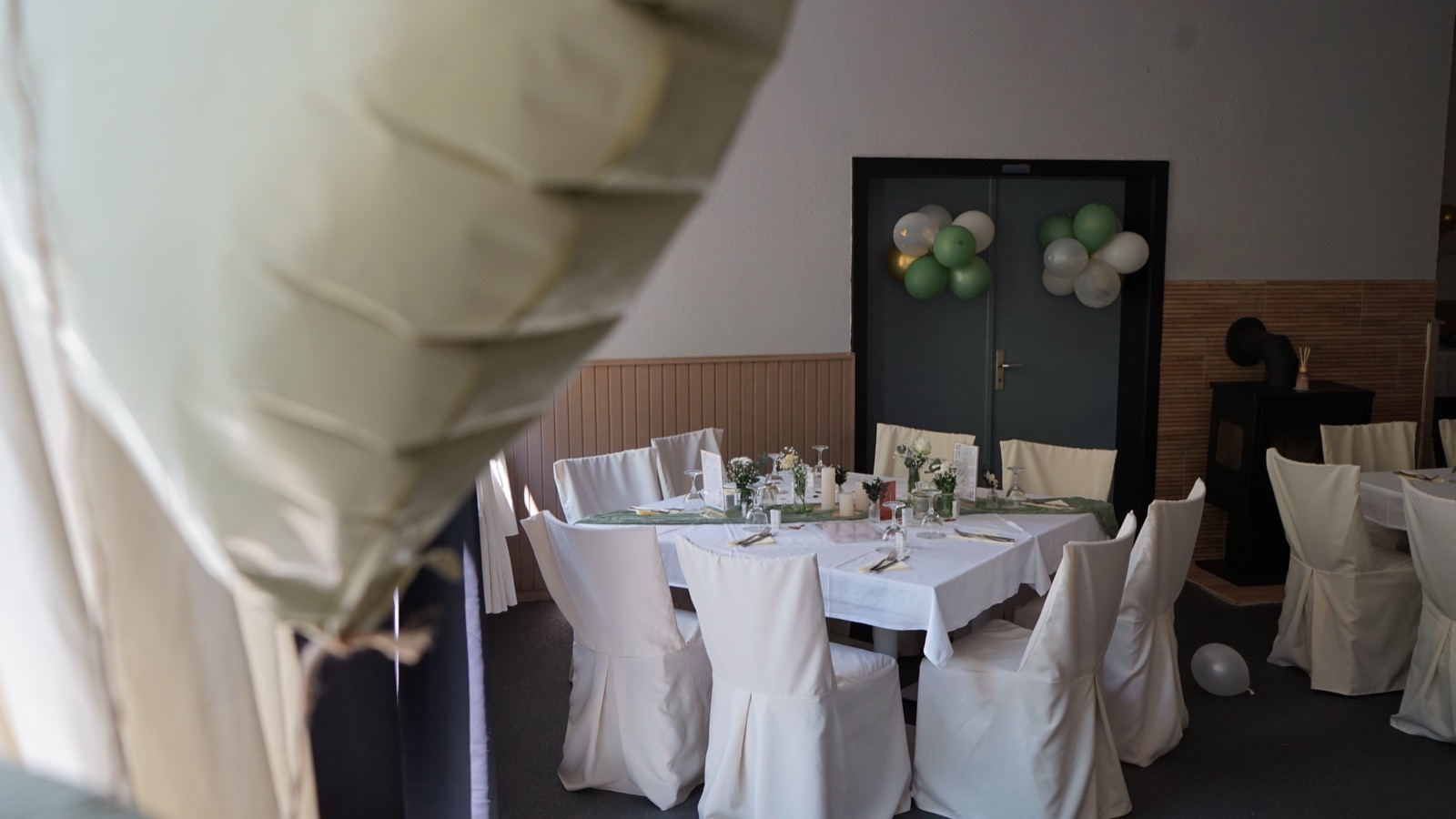 Eingedeckter Tisch mit Ballondekoration im Saal