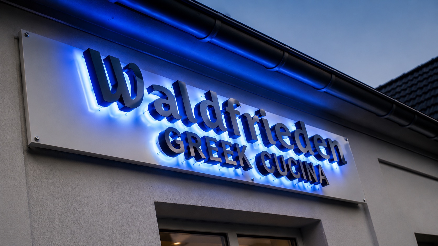 Waldfrieden Greek Cucina — beleuchtetes Schild an der Außenwand des Restaurants